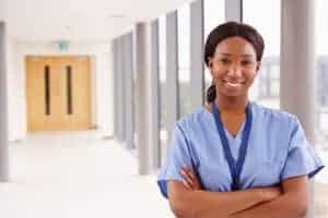 Portrait Of Female Nurse Standing In Hospital Corridor Portrait Of Female Nurse Standing In Hospital Corridor