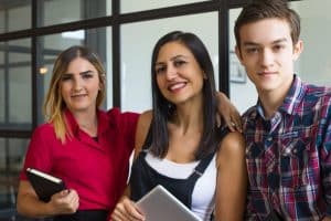 Portrait of happy young student friends embracing and smiling