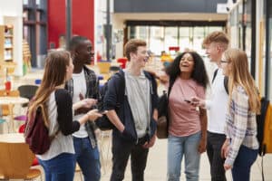 Student Group Socializing In Communal Area Of Busy College