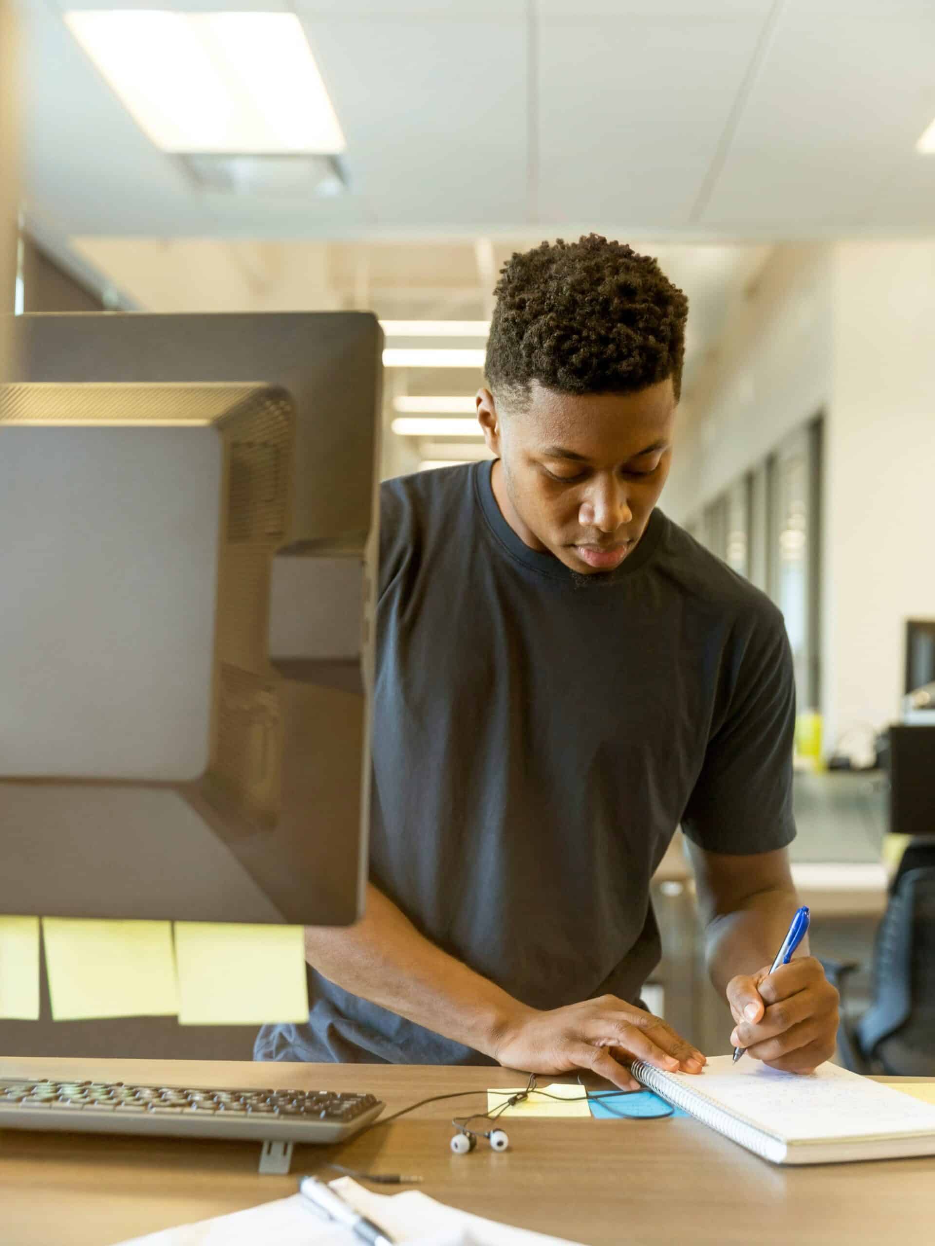 Student working from standing desk at library.