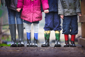 Group of children's muddy wellington boots